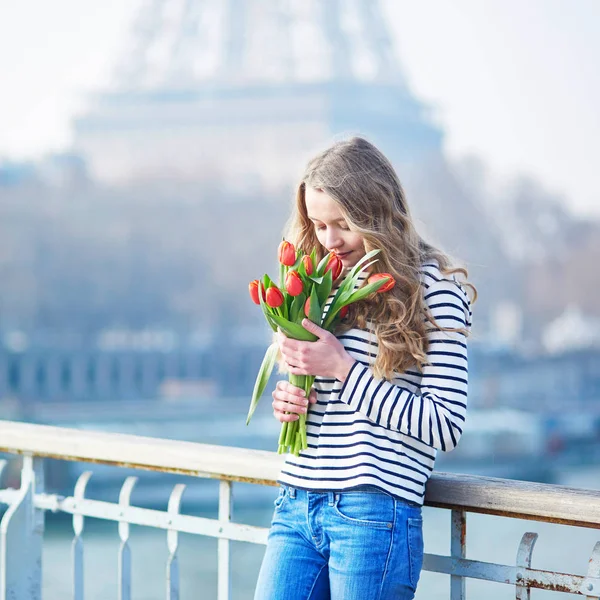 Девушка с кучей красных тюльпанов возле Эйфелевой башни — стоковое фото