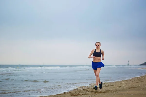 Jeune femme fitness running jogging sur la plage — Photo