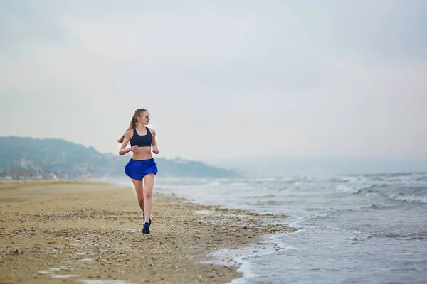 Jeune femme fitness running jogging sur la plage — Photo