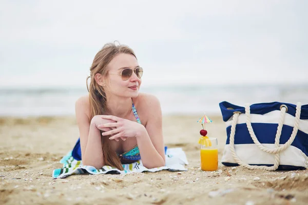 Mujer relajante y tomando el sol en la playa — Foto de Stock