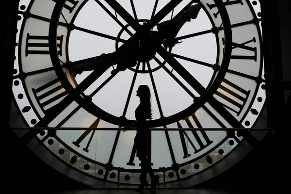 Γυναίκα σιλουέτα στέκεται μπροστά από το μεγάλο ρολόι — Φωτογραφία Αρχείου
