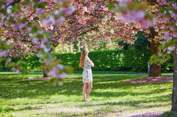 Beautiful young woman in blooming spring park — Stock Photo, Image