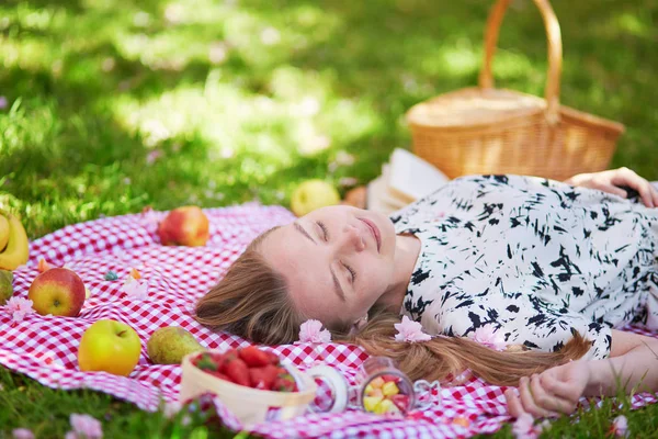 Krásná mladá žena s piknik v parku — Stock fotografie