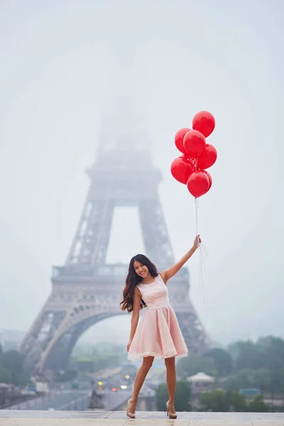 Mujer parisina con globos rojos frente a la torre Eiffel —  Fotos de Stock