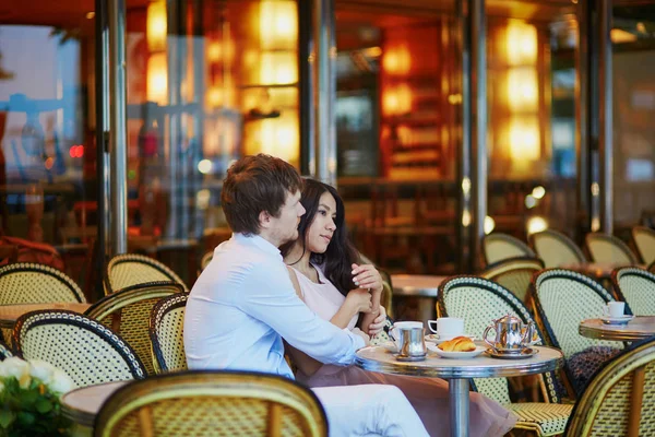 Pareja bebiendo café y comiendo croissants en café parisino — Foto de Stock