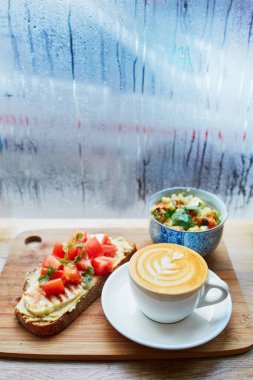 Humus ve domatesli sandviç, salata ve taze sıcak cappuccino kahve