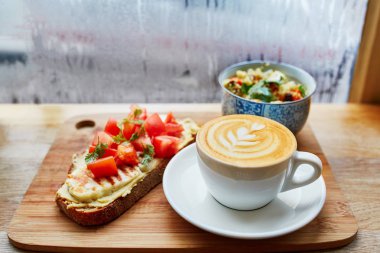 Humus ve domatesli sandviç, salata ve taze sıcak cappuccino kahve
