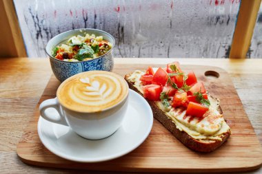 Humus ve domatesli sandviç, salata ve taze sıcak cappuccino kahve