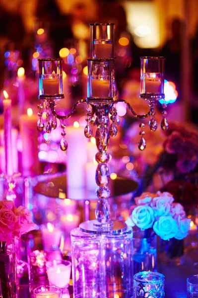 Conjunto de mesa com velas para um evento festivo, festa ou recepção de casamento, em luz roxa — Fotografia de Stock