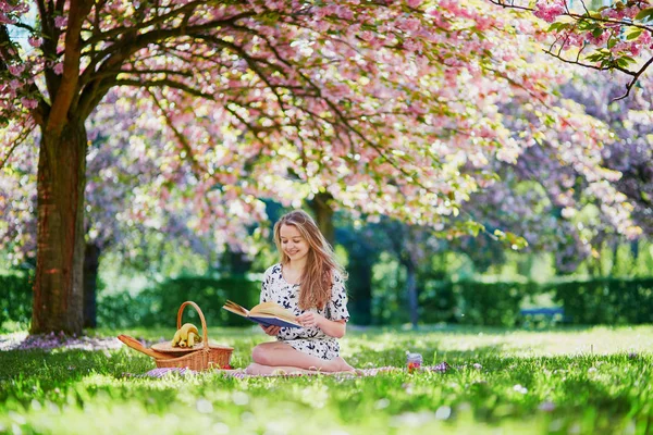 Beautiful young woman in blooming spring park — Stock Photo, Image