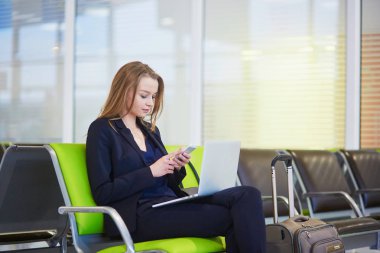 Uluslararası Havaalanı terminal, telefonunu kontrol kadında