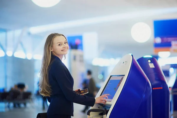 Молодая деловая женщина проводит самостоятельную регистрацию в международном терминале аэропорта — стоковое фото