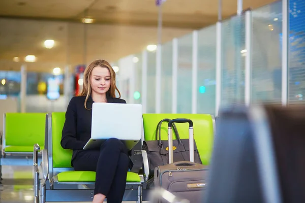 Mulher no terminal do aeroporto internacional, trabalhando em seu laptop — Fotografia de Stock