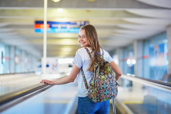 A hátizsák és a nemzetközi repülőtér, a travelator poggyász folytasson turista lány — Stock Fotó