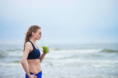 Koşucu kız içme yeşil sebze smoothie