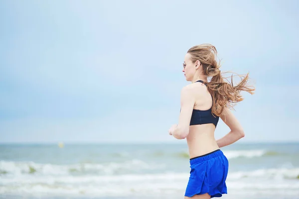 Jeune femme fitness running jogging sur la plage — Photo