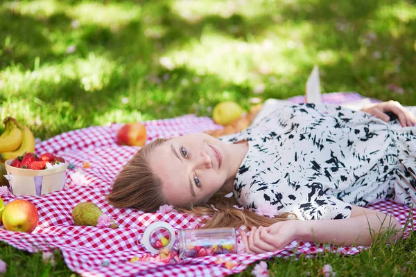 Красива молода жінка має пікнік в парку — стокове фото