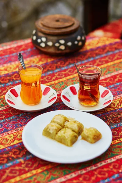 Турецька оранжевого і чорного чаю в традиційних окуляри і пахлава — стокове фото