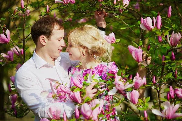 Casal sob a árvore de magnólia florescente em um dia de primavera — Fotografia de Stock