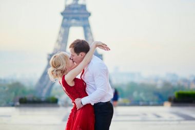 Couple kissing in front of the Eiffel tower in Paris, France clipart