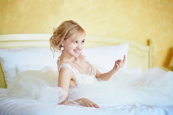 Jovem noiva alegre em vestido de noiva no quarto de hotel — Fotografia de Stock