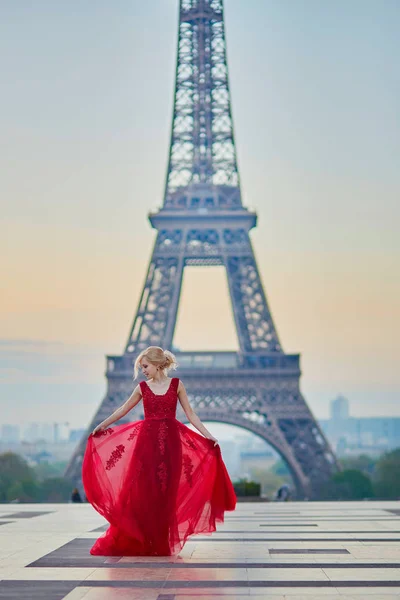 Γυναίκα στο μακρύ κόκκινο φόρεμα που χορεύει κοντά στον Πύργο του Άιφελ στο Παρίσι, Γαλλία — Φωτογραφία Αρχείου