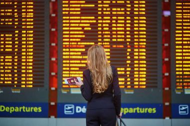 Bilgi tahtaya bakıyor kadınla el bagajı Uluslararası Havaalanı terminal,