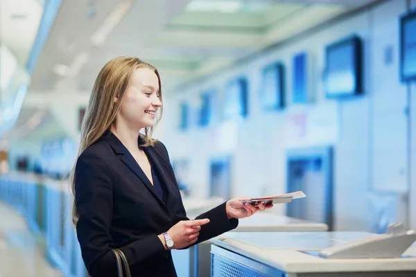 Frau am internationalen Flughafen am Check-in-Schalter und gibt einem Offizier ihren Reisepass — Stockfoto