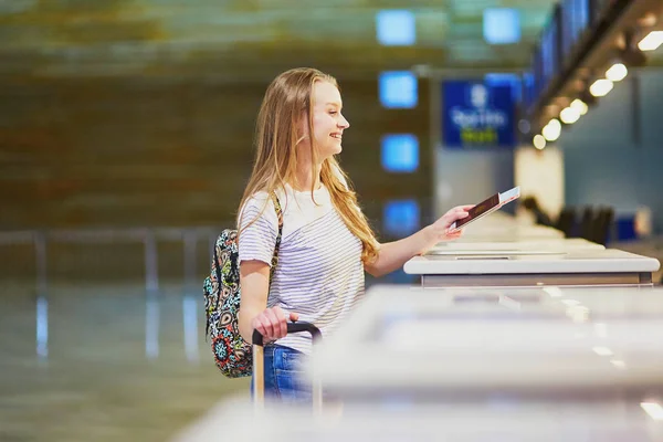 Traveler with backpack in international airport at check-in counter — Stock Photo, Image