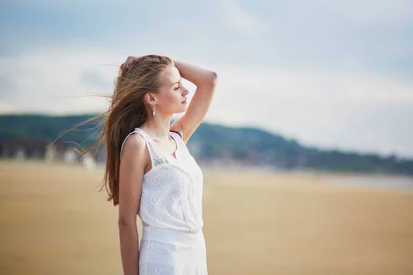 Güzel genç kadının bir kum plajı üzerinde güneş — Stok fotoğraf