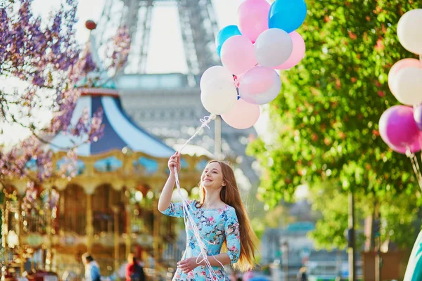 Chica con un montón de globos frente a la torre Eiffel en París —  Fotos de Stock