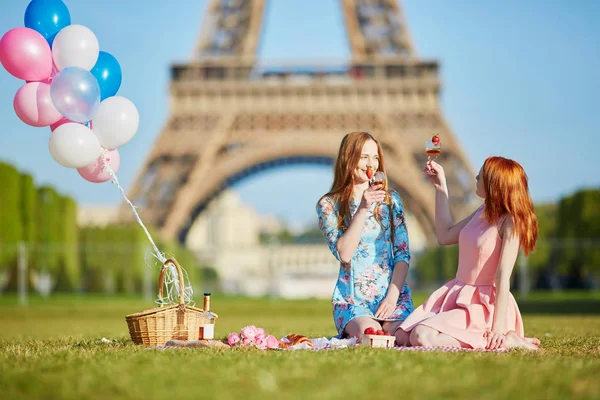 Dos mujeres jóvenes haciendo picnic cerca de la Torre Eiffel en París, Francia —  Fotos de Stock