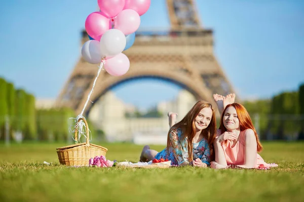 Twee jonge vrouwen hebben picnic in de buurt van de Eiffeltoren in Parijs, Frankrijk — Stockfoto