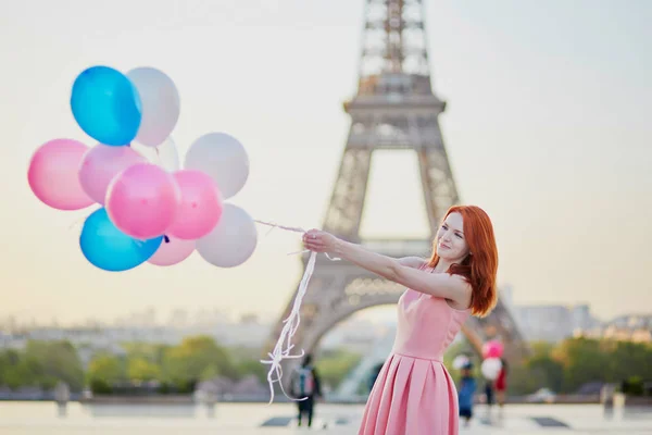 Chica con un montón de globos frente a la torre Eiffel en París —  Fotos de Stock
