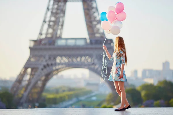 Chica con un montón de globos frente a la torre Eiffel en París —  Fotos de Stock