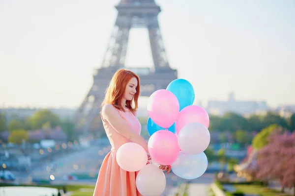 Ragazza con un mucchio di palloncini davanti alla torre Eiffel a Parigi — Foto Stock