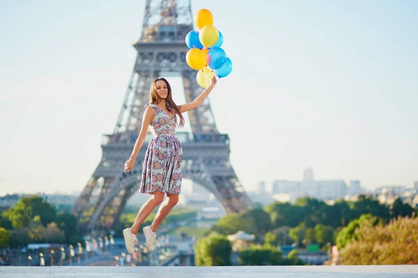 Mujer joven con un montón de globos cerca de la torre Eiffel — Foto de Stock