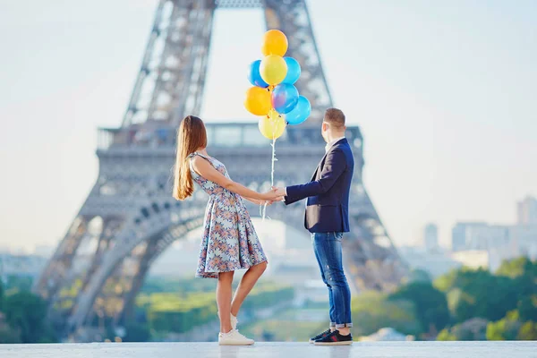 Par med färgglada ballonger tittar på Eiffeltornet — Stockfoto