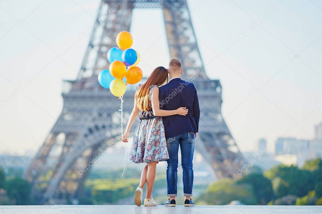Couple with colorful balloons looking at the Eiffel tower