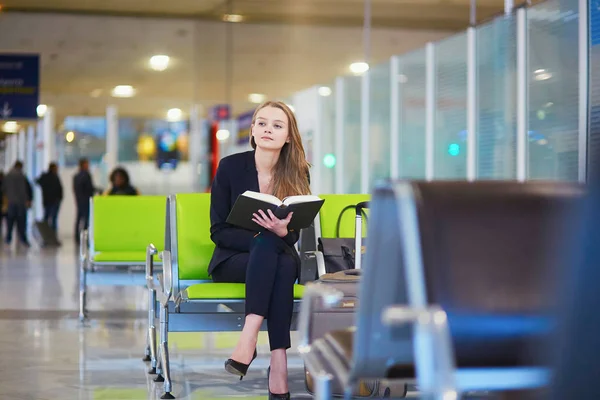 Frau im internationalen Flughafen-Terminal, liest Buch — Stockfoto