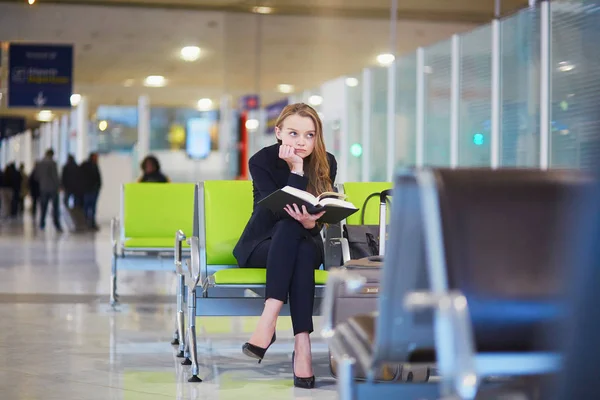 Mulher no terminal do aeroporto internacional, livro de leitura — Fotografia de Stock