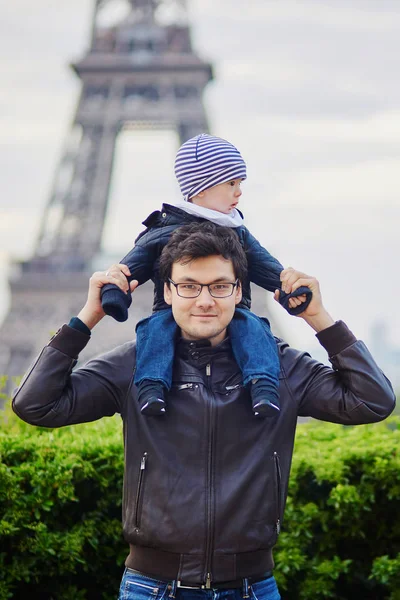 Padre sosteniendo a su hijo sobre hombros cerca de la torre Eiffel —  Fotos de Stock