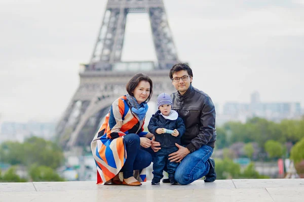 Счастливая семья из трех человек в Париже у Эйфелевой башни — стоковое фото