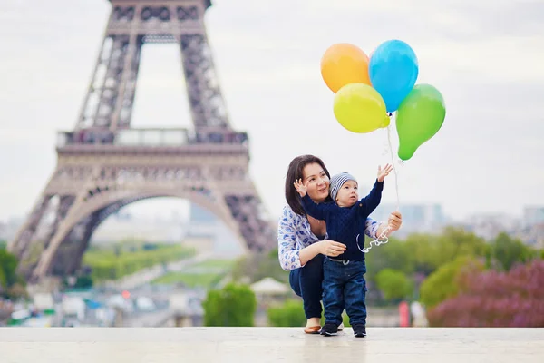 Familia feliz de dos con un montón de globos de colores en París — Foto de Stock