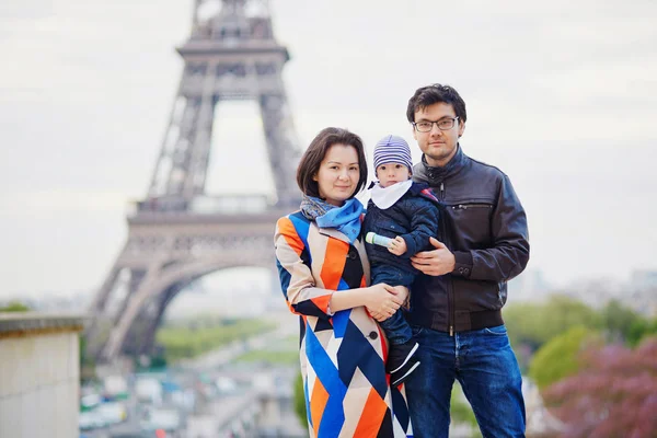 Счастливая семья из трех человек в Париже у Эйфелевой башни — стоковое фото
