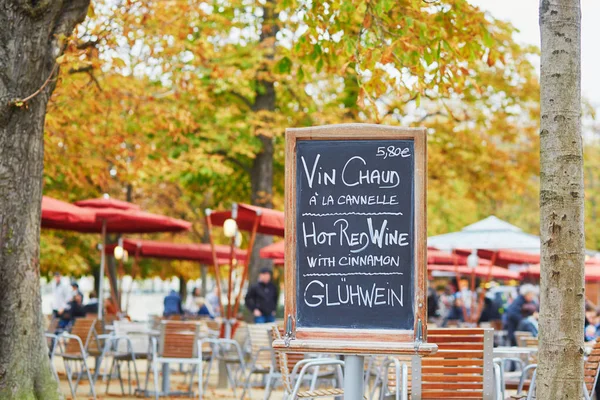 Menyn styrelsen med orden 'varmt vin' på tre språk i parisisk utomhus café — Stockfoto