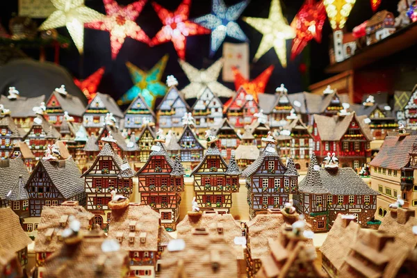 Verschiedene Keramikhäuser und Sternengirlanden auf dem traditionellen Weihnachtsmarkt in Straßburg — Stockfoto