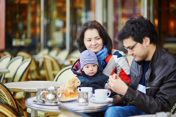 Família feliz de três em Parisiense café ao ar livre — Fotografia de Stock