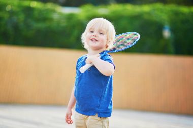 Küçük çocuk parkta badminton oynarken