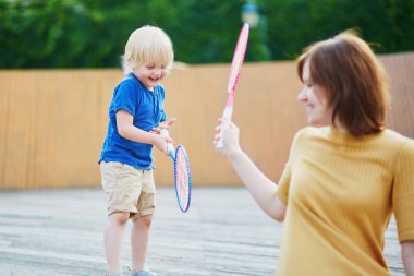 Küçük çocuk anne ile badminton oyun oynamaya